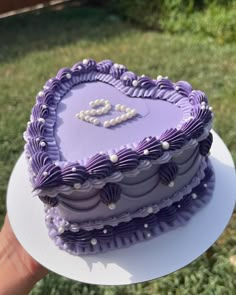 a purple heart shaped cake sitting on top of a white plate