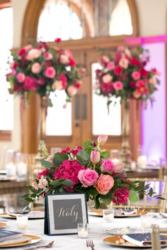 the table is set with pink and red flowers