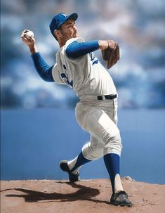 a baseball player throwing a ball on top of a field with water in the background