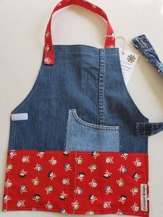 an apron made out of denim with red and blue patches on the front, featuring cartoon characters