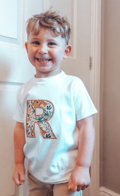 a little boy standing in front of a white door