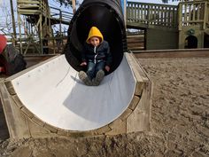 a little boy sitting on top of a slide