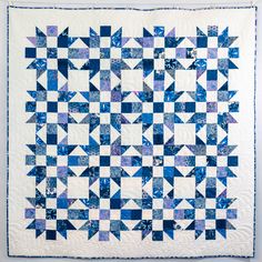 a blue and white quilted wall hanging