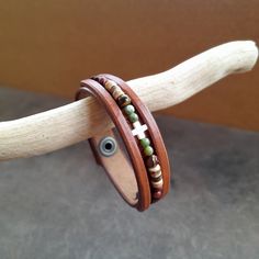 two bracelets are sitting on top of a piece of wood