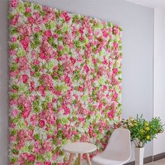 two white chairs sitting in front of a pink and green flowered wall with flowers on it