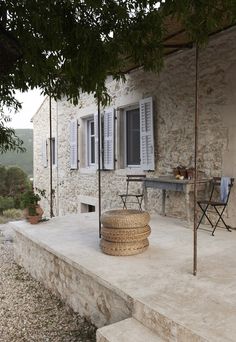 a stone house with white shutters and windows