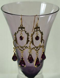 "Vintage Victorian delicate filigree reproduction connectors with three amethyst Swarovski teardrops and the center round dangling rhinestone. Wonderful sparkle and rich purple color. The earrings dangle 1 5/8\" (40 mm) from the ends of gold-filled, nickel free ear wires. You'll love these beauties for your wardrobe, especially when 12 additional Swarovski colors available. Surprisingly light in weight and elegant in appearance. Great for weddings, bridesmaids, and any dressy occasions. Here are Elegant Gold Amethyst Chandelier Earrings, Elegant Gold Chandelier Earrings With Amethyst, Vintage Earrings Victorian, Chandelier Earrings Gold, Purple Chandelier, Gold Filigree Earrings, Antique Locket, Boho Pendant, Filigree Earrings