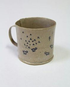 a ceramic cup with animals drawn on it