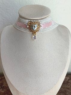 The "Princess at Heart" choker Hand crafted choker perfect for coquette / balletcore / cottagecore / princess / kawaii / dolly / angel / vintage styles. This choker is made with white lace, pink satin ribbon, a crystal charm, and an iridescent bead. lace choker, ribbon choker, heart choker, pink choker, heart necklace, heart charm, costume jewelry, cosplay jewelry Great stocking stuffer, Christmas present, festive. Cute Pink Choker For Party, Pink Ribbon Wedding Jewelry, Elegant Handmade Pink Choker, Pink Adjustable Choker For Wedding, Adjustable Pink Choker For Wedding, Wedding Pink Adjustable Choker, Adjustable Wedding Choker For Valentine's Day, Pink Vintage Choker Jewelry, Cottagecore Princess