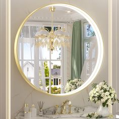 a bathroom with a large round mirror above the sink and flowers on the counter top