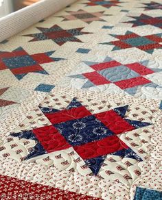 a red, white and blue quilt with stars on it