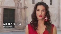 a woman in a red dress is standing near a building and looking at the camera