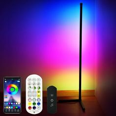 the remote control is next to an electronic device and a lamp on a wooden table