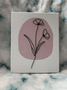 a pink and white square with some flowers on it