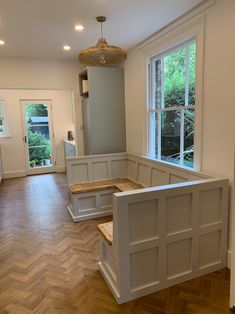 the inside of a house with wood floors and white painted walls, windows, and wooden steps