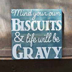 a wooden sign that says, mind your own biscuits and life will be gravy