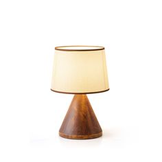 a wooden table lamp with a beige shade on it's side and a white background