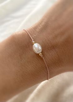 Delicate high luster AAA natural freshwater pearl bracelet made with a dusty pink silk thread and 14kt gold filled beads. The bracelet has a slider bead, which makes it easy to adjust the tightness to your liking. Individually selected high quality pearls make the bracelet truly special and one of a kind. The delicate and minimalist design goes well with both casual and sophisticated looks. Total length of the bracelet: 13in Size of the freshwater pearl is approx. 7mm by 9mm Follow me on INSTAGR Flat Pearl Bracelet, Silk Thread Bracelet, Pearl Bracelet Designs, Jewelry Packaging Diy, Pink Beaded Bracelets, Bracelet Packaging, Pearl Bracelet Gold, Thread Bracelet, Silk Bracelet