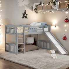 a child's bed with a slide and christmas decorations on the wall behind it