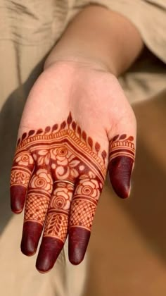 a person's hand with hennap on it and the fingers painted red