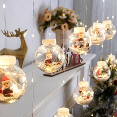 lighted christmas ornaments hanging from the ceiling in front of a mantel with deer figurines on it