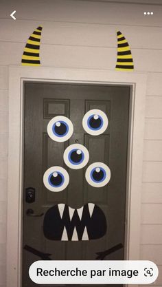 a door decorated to look like a monster with large blue eyes and yellow striped horns