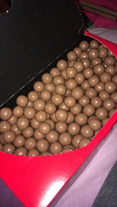 a large box filled with chocolate balls on top of a purple tablecloth covered floor