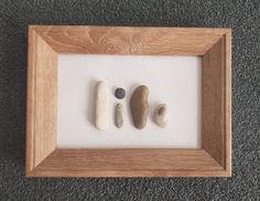 three rocks in a wooden frame on the floor