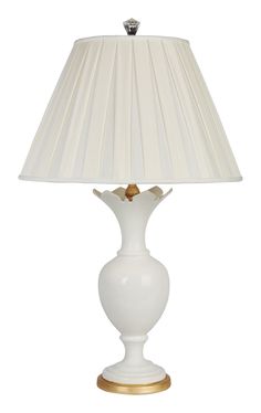 a white lamp with a gold base and shade on it's side, against a white background