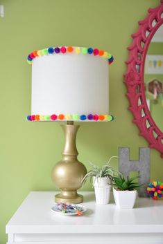 a table with a lamp, mirror and pictures on the wall