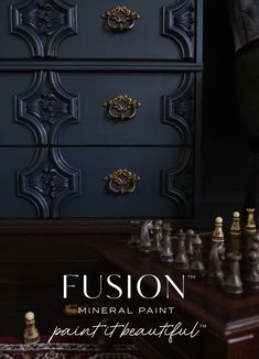 a black dresser with gold handles and knobs next to a chess set on a rug