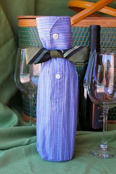 a wine bottle wrapped in a bow next to some wine glasses