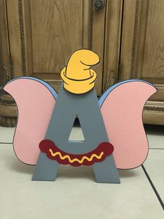 a wooden letter with a cartoon character sitting on it's side and the letter a in the middle