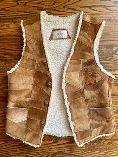 "1970s Patchwork Suede Sherpa Vest: Unisex 70s Vintage IDM Faux Shearling Lined Western Hippie Snap Button Outerwear Vest  - Made in Mexico  This vintage brown leather suede vest from IDM is perfect for those who want to add a western and hippie vibe to their wardrobe. The mid-length vest features a snap closure and is lined with cozy shearling for warmth during the colder seasons.  Size: 36 / Fits a size Medium Measurements:  Pit to Pit - 18\" Shoulder to Shoulder -15\" Total Length - 24\" Brand: IDM Contents: Leather, Polyester/Acrylic Lining Condition: Overall good pre-loved condition. Please reference all photos." Come In, Brown Fur Vest, Burgundy Scarf, Fox Fur Vest, Thrift Inspo, Sherpa Vest, Brown Vest, Suede Vest, Outerwear Vest