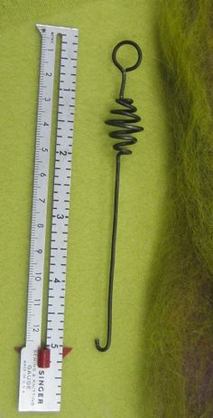 a needle and measuring ruler on a green surface