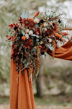 an arrangement of flowers and greenery is on display