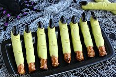 halloween treats are arranged in the shape of toothpicks on a black platter