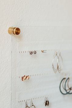 there are many earrings hanging on the wall