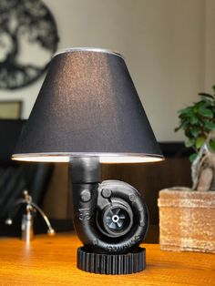 a lamp that is sitting on top of a table next to a potted plant