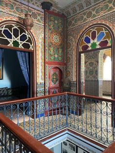 an ornate balcony area with colorful walls and stained glass windows, decorated with intricate designs