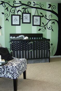 a baby's room decorated in black and white with a tree painted on the wall