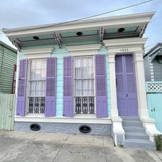 a house with purple and blue shutters on the front