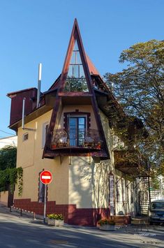 a house with a triangular shaped roof and balconies