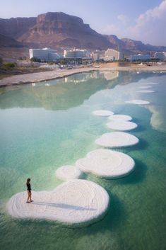 a person standing in the middle of some water with white circles floating on top of it