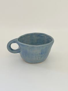 a small blue bowl sitting on top of a white table