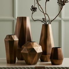 a group of vases sitting on top of a table next to each other with flowers in them