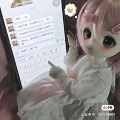 a close up of a doll near a cell phone