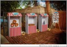 three boxes with donuts in them are on the brick floor next to a fence