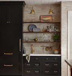 a kitchen with black cabinets and gold pulls on the doors is pictured in this image