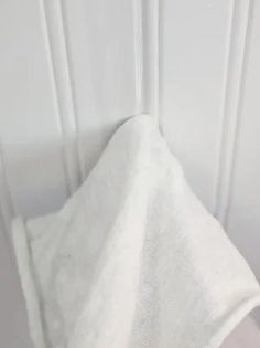 a white towel hanging on the side of a wall